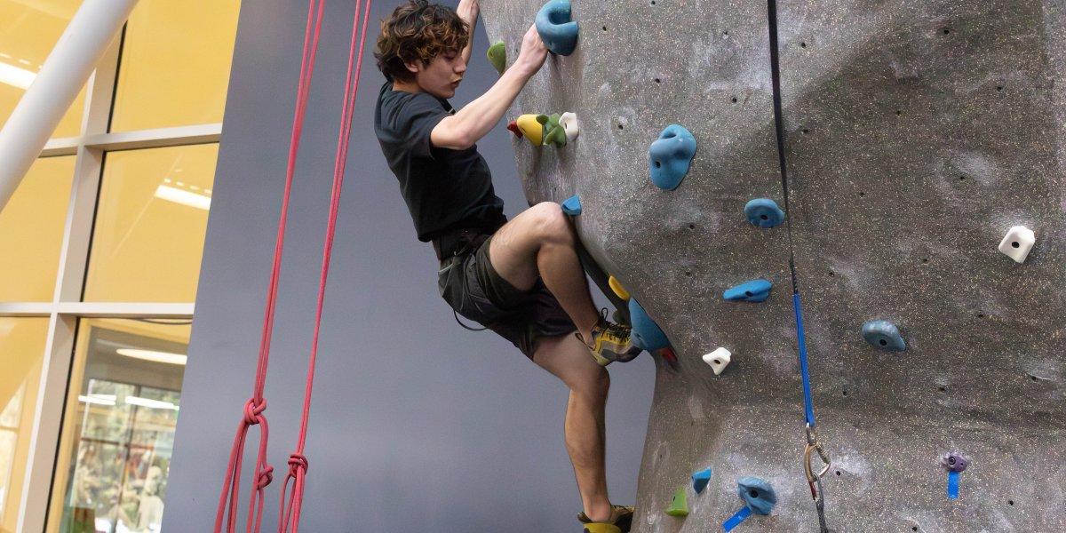 Matthe Menzi carefull places his foot on the hold at the climbing wall